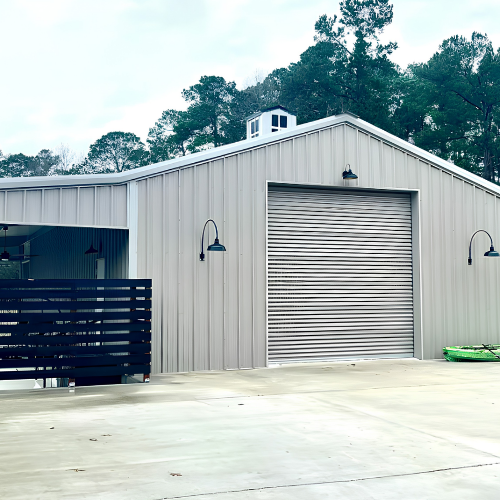 Custom metal building with a large roll-up door, covered outdoor area and concrete driveway in Louisiana.