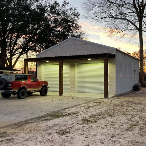 Custom metal garage with a brick front, two roll-up doors and covered entrance in South Louisiana.
